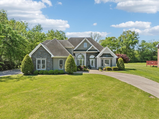craftsman inspired home featuring stucco siding, french doors, stone siding, and a front lawn