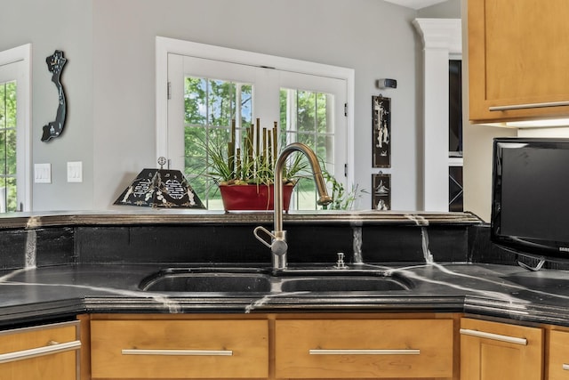 kitchen featuring brown cabinets, dark countertops, and a sink