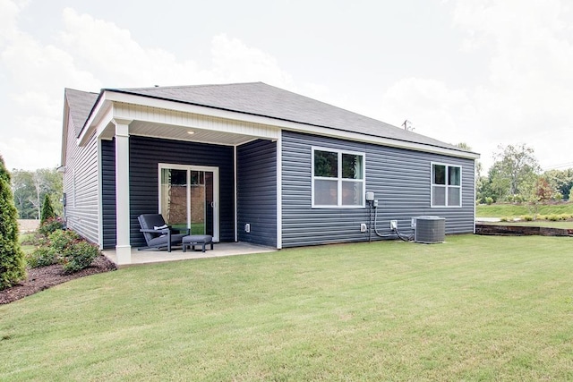 rear view of property featuring a patio, a yard, and central AC unit
