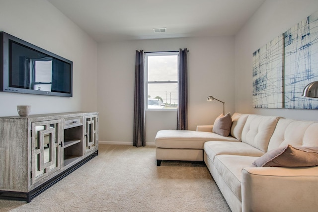 living area featuring visible vents, baseboards, and light carpet