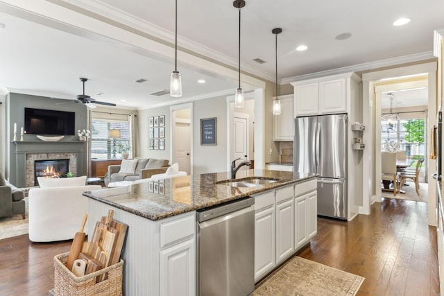 kitchen featuring white cabinets, a sink, stainless steel appliances, dark wood-type flooring, and ornamental molding