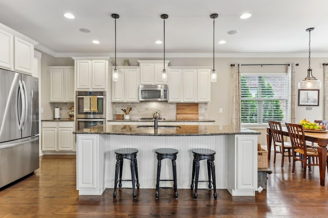 kitchen featuring backsplash, stainless steel appliances, a breakfast bar, and a sink