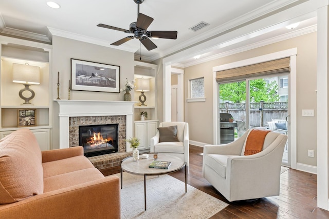 living area featuring baseboards, dark wood-style flooring, ceiling fan, and a fireplace