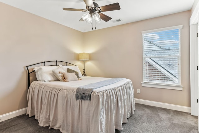 carpeted bedroom featuring baseboards, a ceiling fan, and visible vents