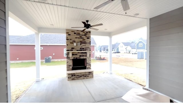 view of patio with a residential view, a ceiling fan, and a large fireplace