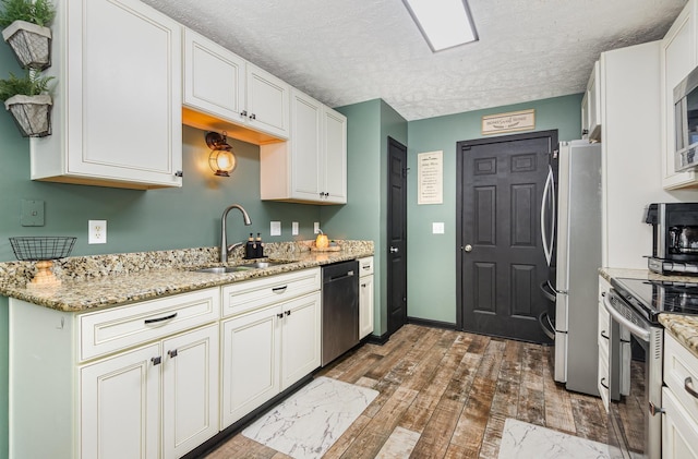 1904 Portway Rd, Spring Hill, TN 37174 - kitchen with stainless steel appliances, a sink, a textured ceiling, white cabinetry, and light stone countertops