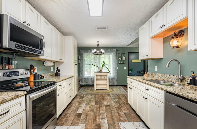 1904 Portway Rd, Spring Hill, TN 37174 - kitchen featuring stainless steel appliances, a sink, dark wood finished floors, a chandelier, and a textured ceiling