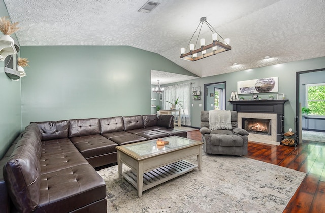 1904 Portway Rd, Spring Hill, TN 37174 - living area with a chandelier, hardwood / wood-style floors, a textured ceiling, lofted ceiling, and a fireplace with flush hearth