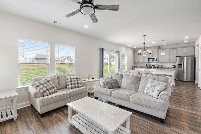 living area featuring baseboards, ceiling fan with notable chandelier, recessed lighting, and visible vents