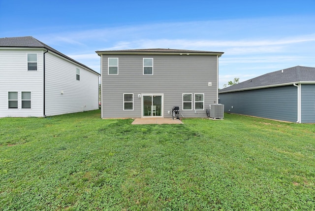 rear view of property featuring a lawn, a patio area, and central AC
