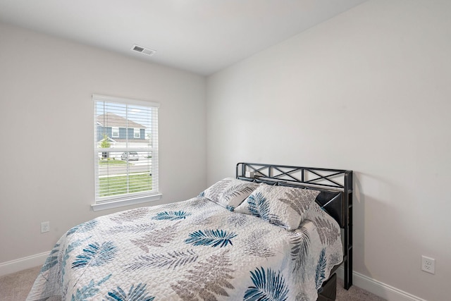 carpeted bedroom featuring visible vents and baseboards