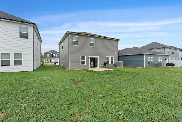 back of property with a lawn, a patio, and central AC