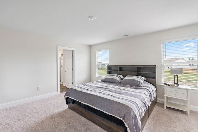 carpeted bedroom featuring baseboards and visible vents