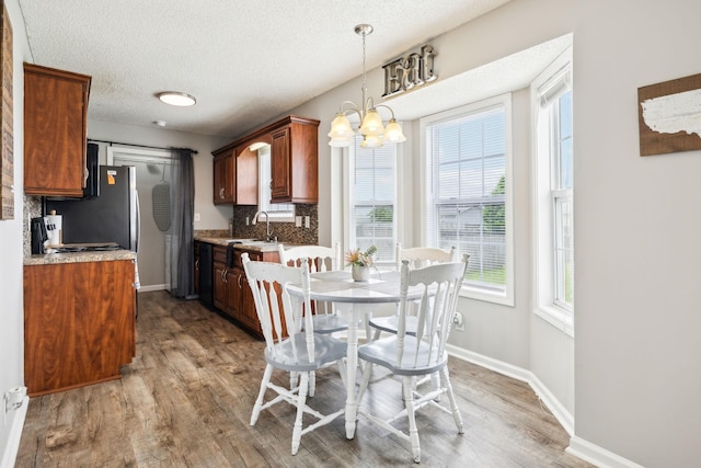 817 Stableford Rd, Oak Grove, KY 42262 - dining room with baseboards, light wood-type flooring, a textured ceiling, and a chandelier