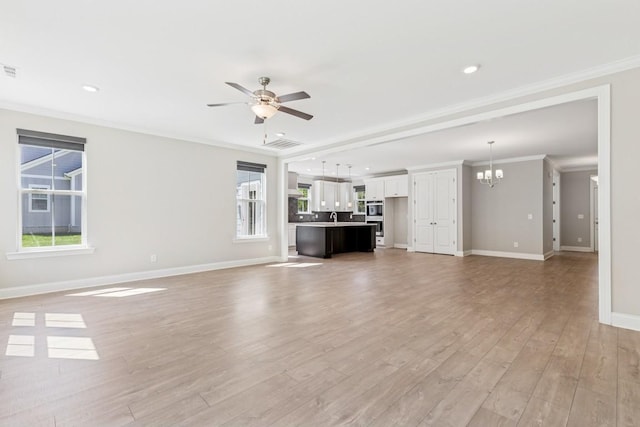 7205 Lake Rd, Fairview, TN 37062 - unfurnished living room featuring a chandelier, a ceiling fan, baseboards, light wood finished floors, and crown molding