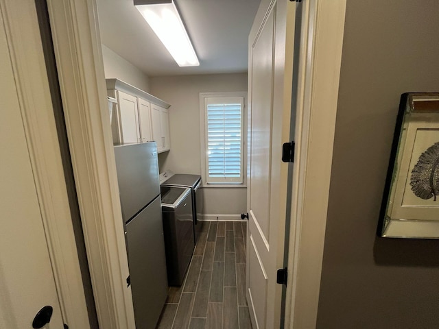 clothes washing area with independent washer and dryer, baseboards, dark wood-style floors, and cabinet space
