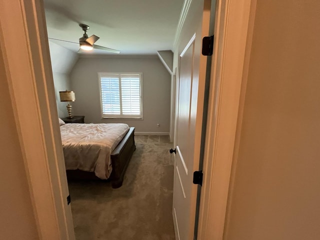 carpeted bedroom with a ceiling fan, baseboards, and vaulted ceiling