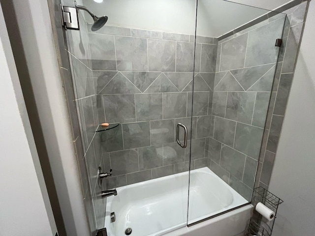 bathroom with bath / shower combo with glass door