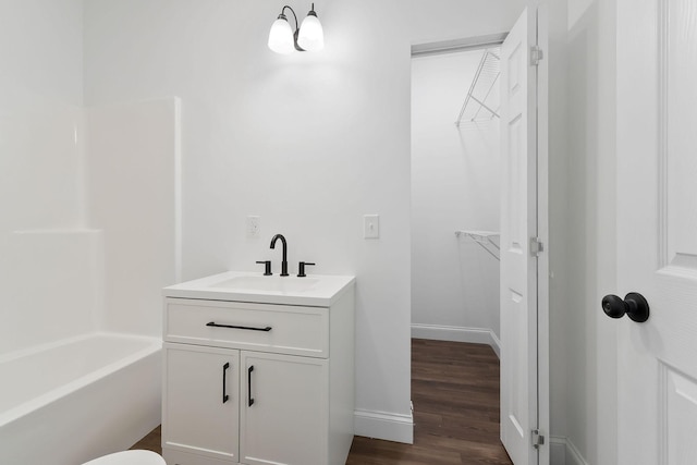 795 Lowery Ln, Mcminnville, TN 37110 - bathroom featuring a walk in closet, vanity, baseboards, wood finished floors, and  shower combination