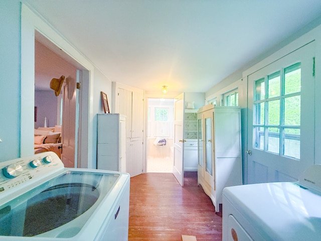 laundry area featuring dark wood-style flooring, laundry area, washer / dryer, and a wealth of natural light