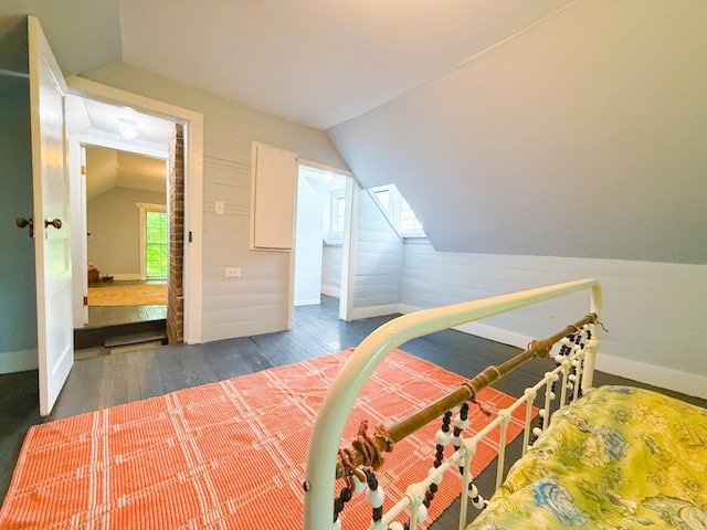 bedroom featuring wood finished floors, baseboards, and lofted ceiling