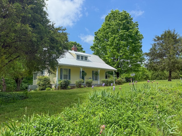 view of front of property featuring a porch, a chimney, and metal roof