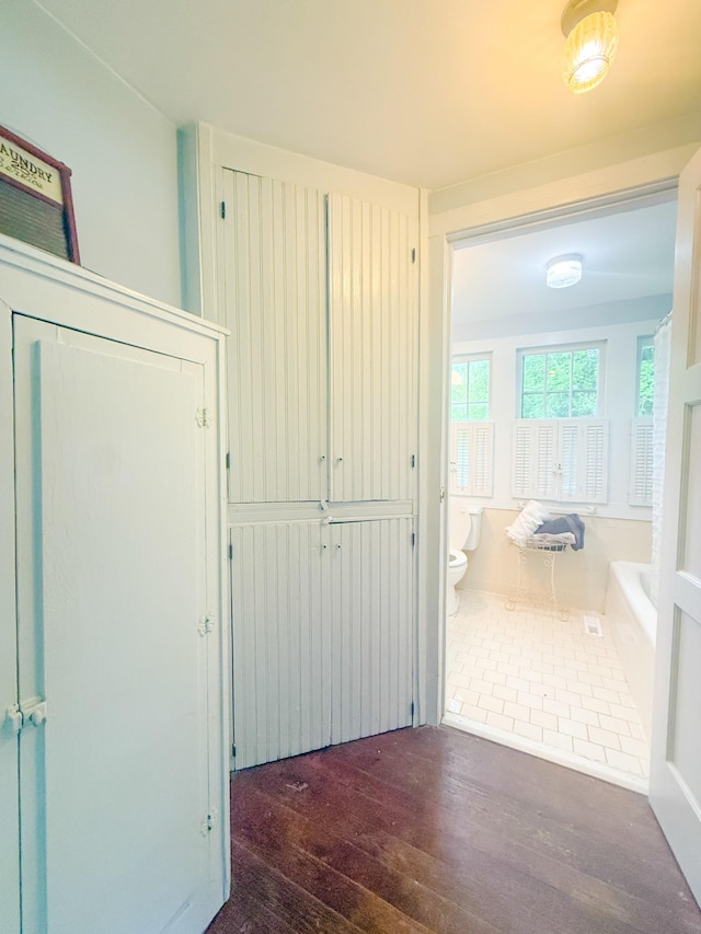 corridor with hardwood / wood-style flooring