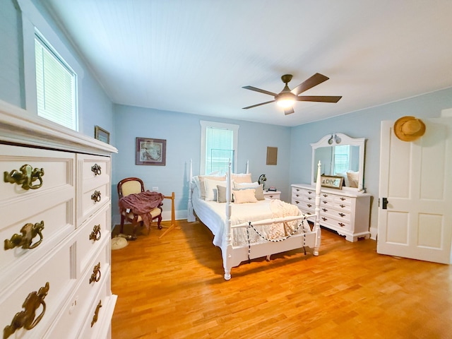 bedroom with baseboards, a ceiling fan, and light wood finished floors