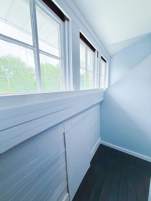interior space featuring baseboards and dark wood-type flooring