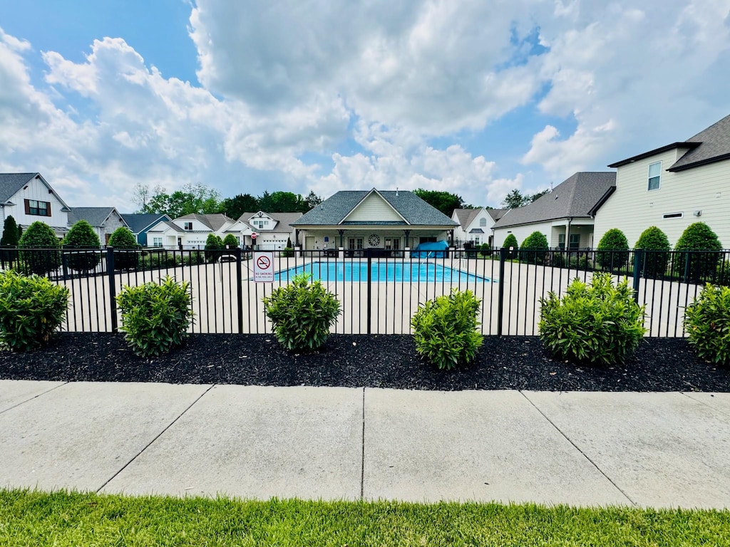 community pool with fence and a residential view