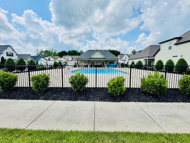 community pool with fence and a residential view
