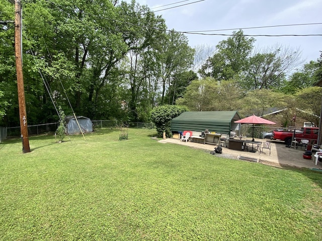 view of yard with a storage shed, an outbuilding, a fenced backyard, and a patio area