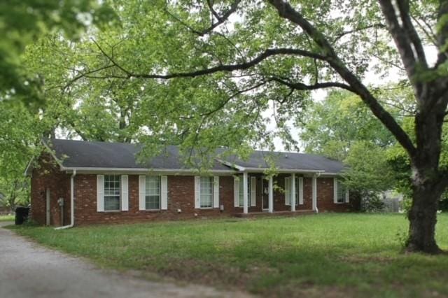 ranch-style home featuring brick siding and a front yard