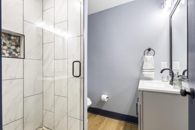 full bathroom with vanity, a stall shower, toilet, and wood finished floors