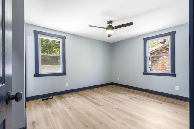unfurnished room with light wood-style floors, ceiling fan, a healthy amount of sunlight, and visible vents