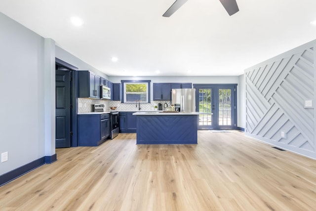 kitchen with light countertops, blue cabinets, a wealth of natural light, and stainless steel appliances