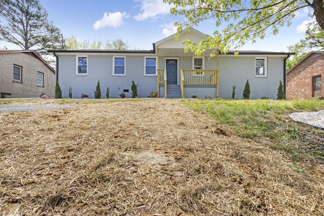 ranch-style home featuring a porch and brick siding