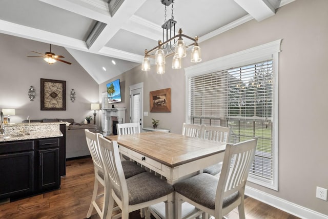 dining space featuring beamed ceiling, dark wood-style flooring, a ceiling fan, a fireplace, and baseboards