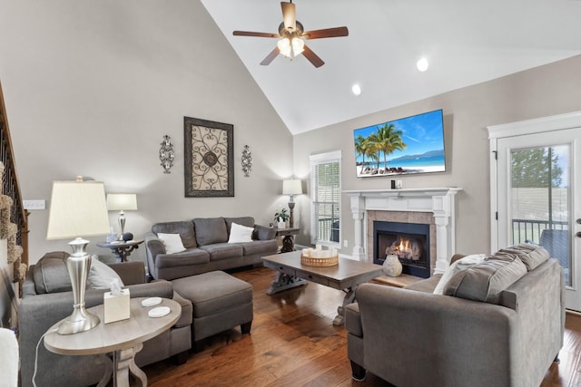 living room featuring high vaulted ceiling, a ceiling fan, wood finished floors, a fireplace, and healthy amount of natural light