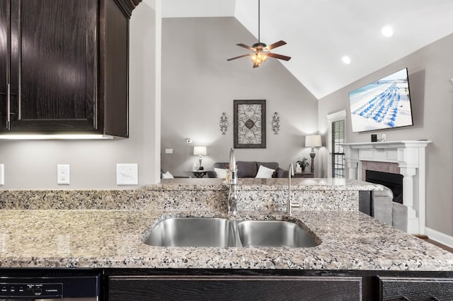 kitchen featuring a sink, open floor plan, a ceiling fan, dishwashing machine, and dark brown cabinetry