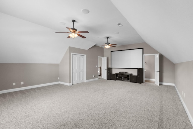 carpeted home theater room featuring ceiling fan, vaulted ceiling, and baseboards