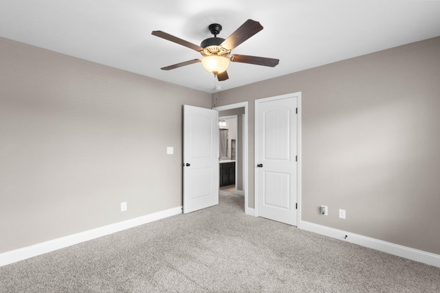 unfurnished bedroom featuring light colored carpet, baseboards, and ceiling fan