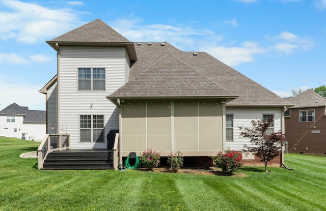 rear view of property with a lawn, a shingled roof, and a wooden deck