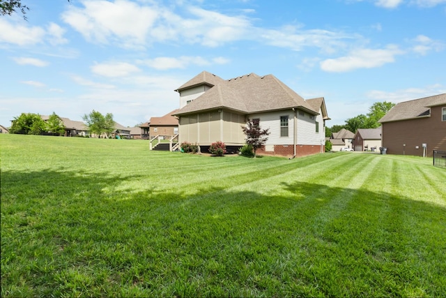 view of grassy yard featuring a sunroom
