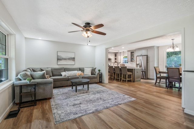 1780 Warren Hollow Rd, Nolensville, TN 37135 - living room with wood finished floors, ceiling fan, a textured ceiling, baseboards, and a chandelier