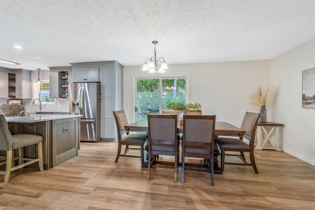 1780 Warren Hollow Rd, Nolensville, TN 37135 - dining area featuring a chandelier, healthy amount of natural light, light wood-style floors, baseboards, and a textured ceiling