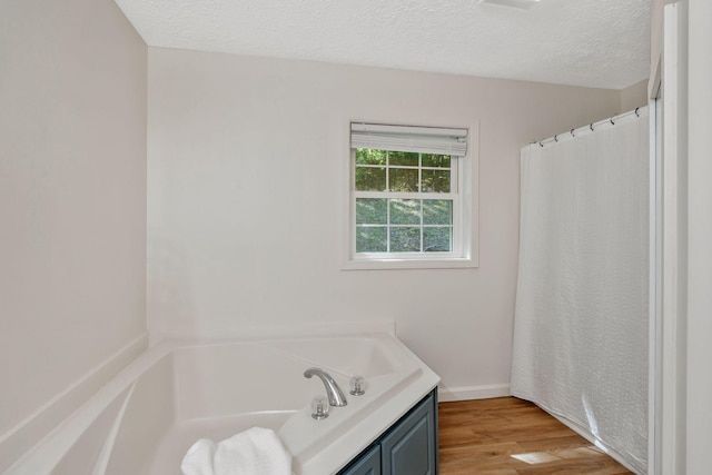 1780 Warren Hollow Rd, Nolensville, TN 37135 - full bathroom featuring wood finished floors, a bath, baseboards, a textured ceiling, and a shower with curtain