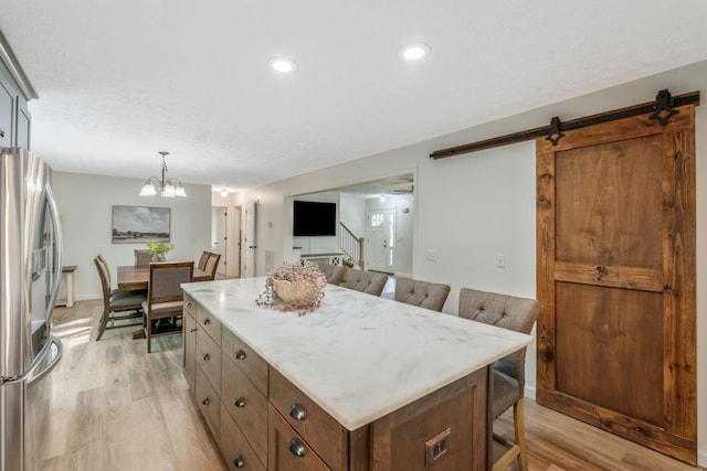 1780 Warren Hollow Rd, Nolensville, TN 37135 - kitchen with stainless steel refrigerator with ice dispenser, light wood finished floors, a kitchen breakfast bar, a center island, and a chandelier