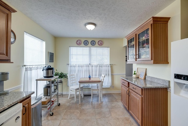 2510 Port Kembla Dr, Mount Juliet, TN 37122 - kitchen featuring white appliances, a textured ceiling, brown cabinetry, stone counters, and glass insert cabinets