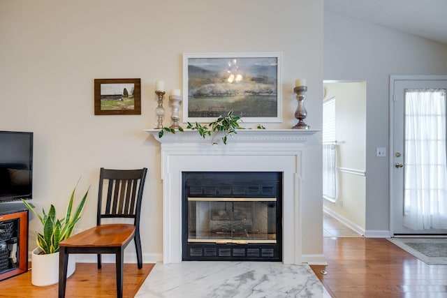 2510 Port Kembla Dr, Mount Juliet, TN 37122 - living area featuring baseboards, vaulted ceiling, a fireplace with flush hearth, and wood finished floors